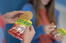 A student holding a smoothie sitting next to a CinnaFuego Toast Crunch Bar