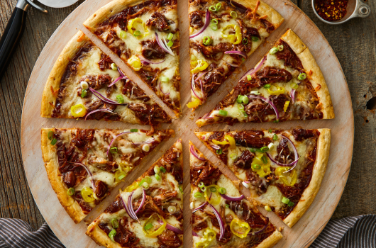 A pizza with different toppings on a wooden board.